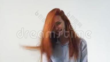 美丽的女孩，有着奢华的红色头发，摆着姿势，在镜头前微笑